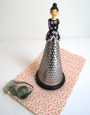 cheese grater with lady's doll head on top