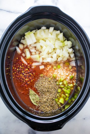 Vegetables and broth in a slow cooker for seafood cioppino