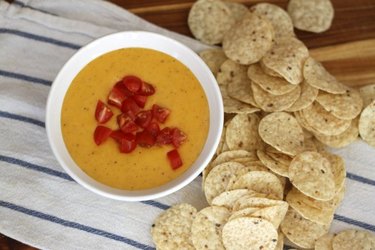 Top cheese dip with tomatoes for color.