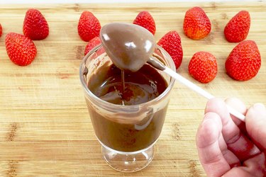 Dipping the strawberry into chocolate