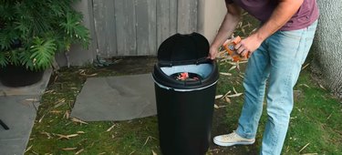 Person cleaning garbage can