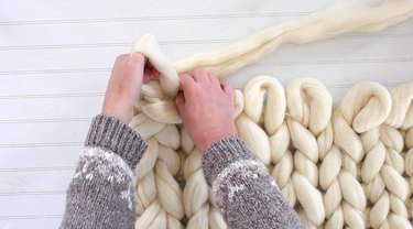 pull yarn through the two loops to create another 4-inch loop