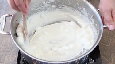 Stirring melted marshmallows in pan.