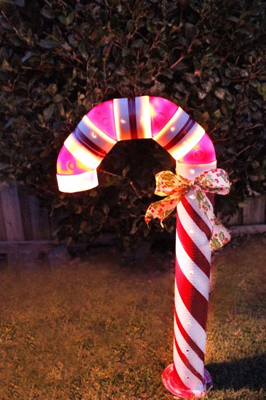 lighted candy cane decoration outside at night