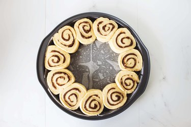 Cinnamon rolls arranged neatly in a baking pan.