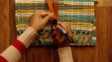 Assembling upcycled no-sew clutch from a placemat and belt