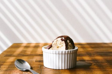 Peanut butter ice cream with a chocolate shell in a white ramiken