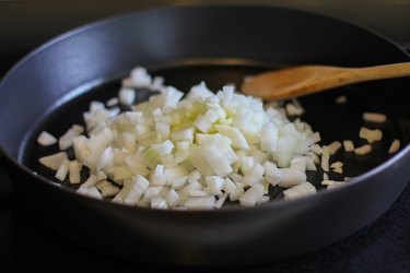 onion sautéing in a paella pan
