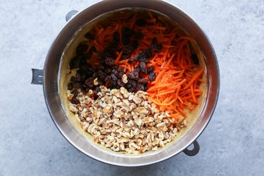 Cake batter with grated carrot, shredded coconut, raisins, and walnuts