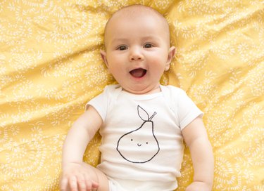 Baby with screen printed pear design on onesie