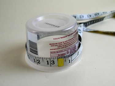 A tailors tape wrapped around a plastic tub.