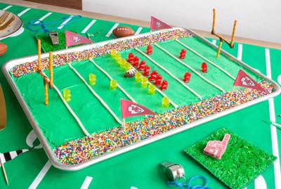DIY stadium cake on table with whistles and foam finger