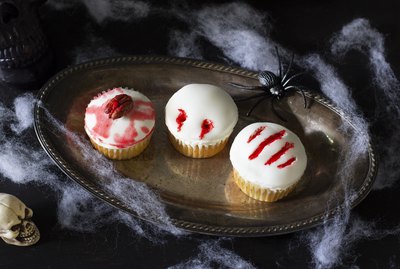 Three cupcakes decorated with zombie brain, vampire bite & monster claw
