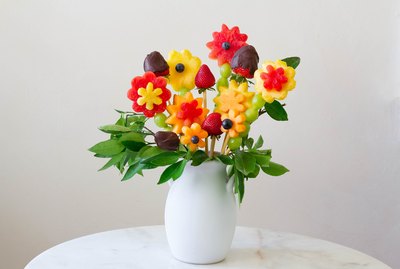 DIY edible fruit flower arrangement in white vase on table