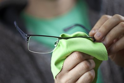 Midsection Of Man Cleaning Eyeglasses