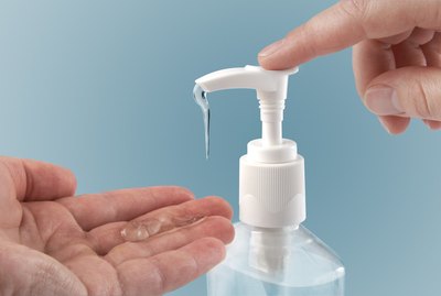 Photograph of a finger pumping sanitizer onto hand
