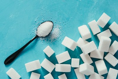 Top view of white sugar cubes on blue concrete background