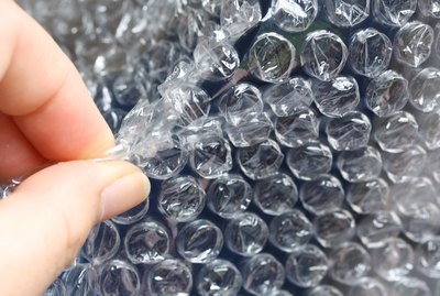 Close-Up Of Cropped Hand Popping Bubble Wrap