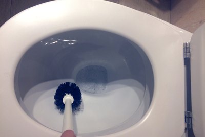 Daily perspective: Cropped hand of person cleaning toilet bowl. Top view.