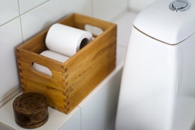 Toilet paper in crate on bathroom shelf