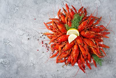 Crayfish. Red boiled crawfishes on table in rustic style, closeup. Lobster closeup. Border desig. Top view
