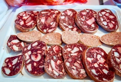 Selling chopped headcheese and white sausage on stall, street market