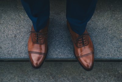 Low Section Of Man Wearing Shoes While Standing On Steps