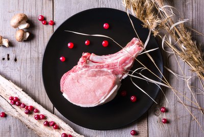 Fresh deer meat on black plate and wooden table