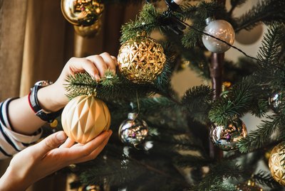 closeup of woman hand decorating Christmas tree
