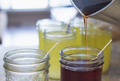 Pouring hot soy wax into glass jars