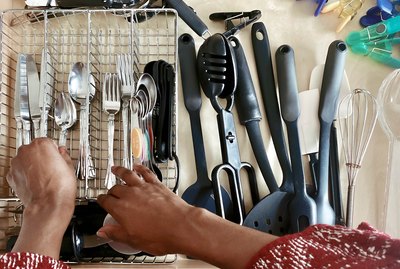 Close-Up of Woman Arranging Spoons in Cutlery Drawer
