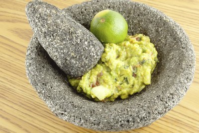 Molcajete Mortar Pestle Bowl Filled With Guacamole And A Lim
