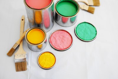 open paint cans and paint brushes on the floor