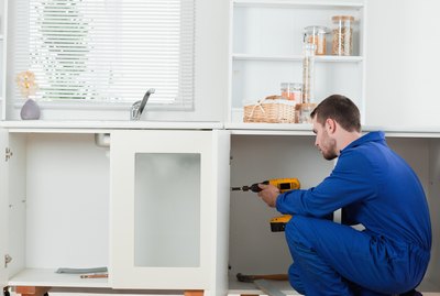 Good looking handyman fixing a door