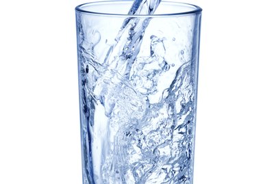 pouring water on glass on white background