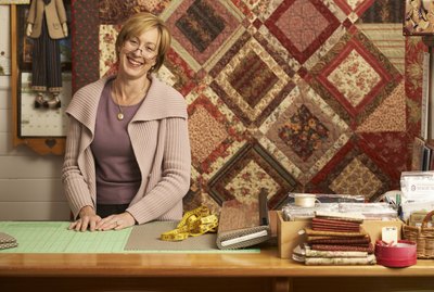 Portrait of mature woman standing behind counter in textile shop