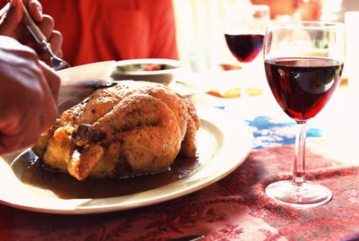 Hands carving roast chicken