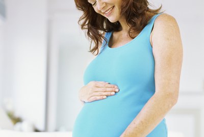 pregnant woman touching her abdomen