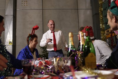 Group of workers celebrating at charismas table in warehouse