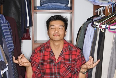 Man in pajamas sitting in yoga position in closet