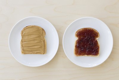 Slices of bread on plates with peanut butter and jelly