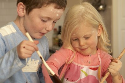 Sister and brother (4-5,8-9) baking in kitchen