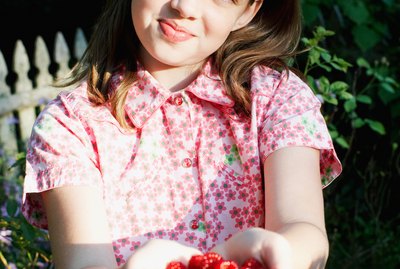 Girl posing with raspberries in cupped hands