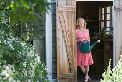 Woman with watering can posing in doorway