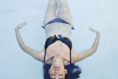 Woman floating in swimming pool