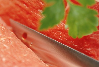 Raw beef with meat cleaver and herb, close-up