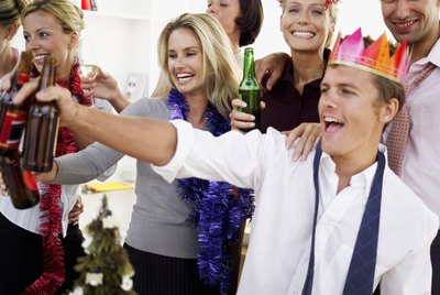 close-up of co-workers celebrating with beers at a office party