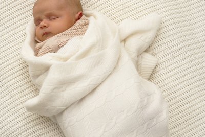 Baby boy (0-3 months) wrapped in blanket, sleeping