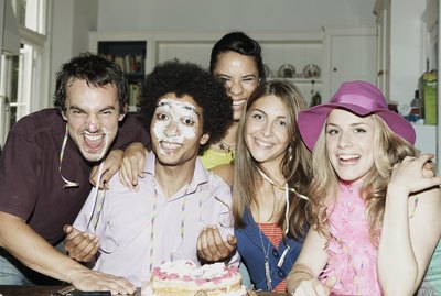Man with icing on his face posing with friends