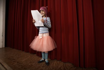 Girl (5-7) practicing lines on stage